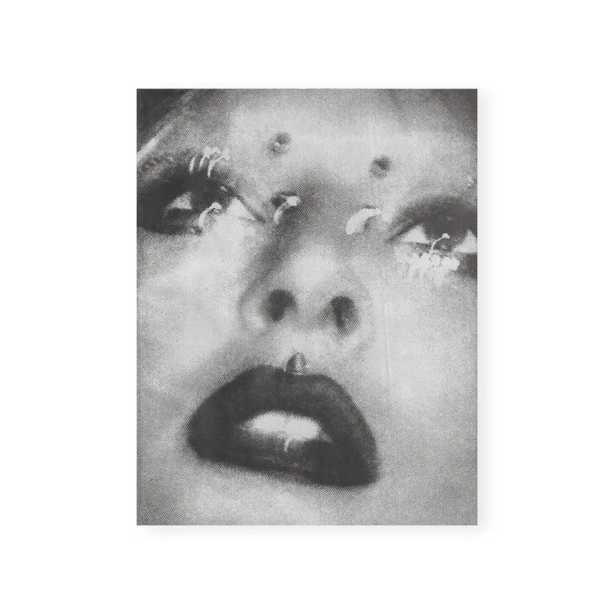 Close-up, black and white image of a person's face with dark lips and light eyes.