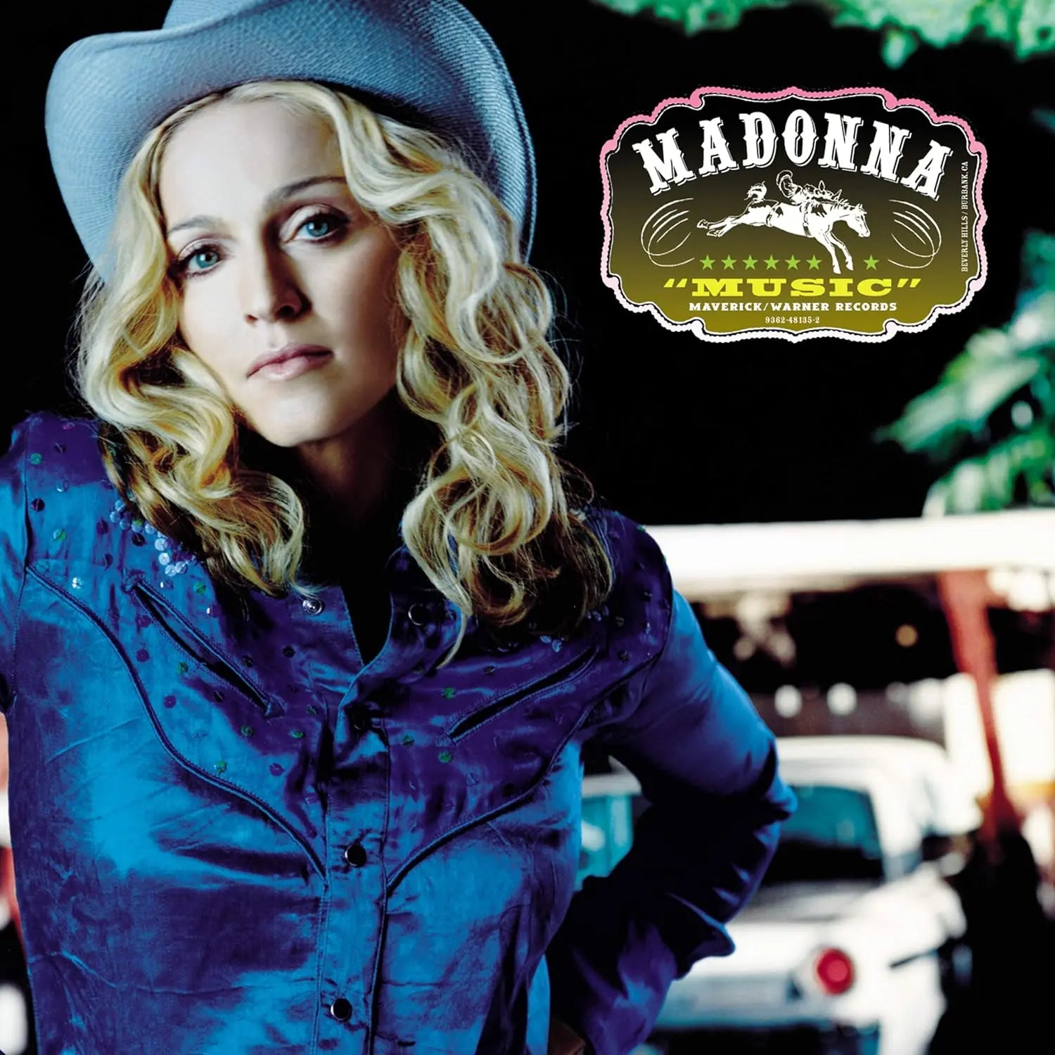 Madonna in a cowboy hat and blue shirt, with album title "Music" in a western-style logo.