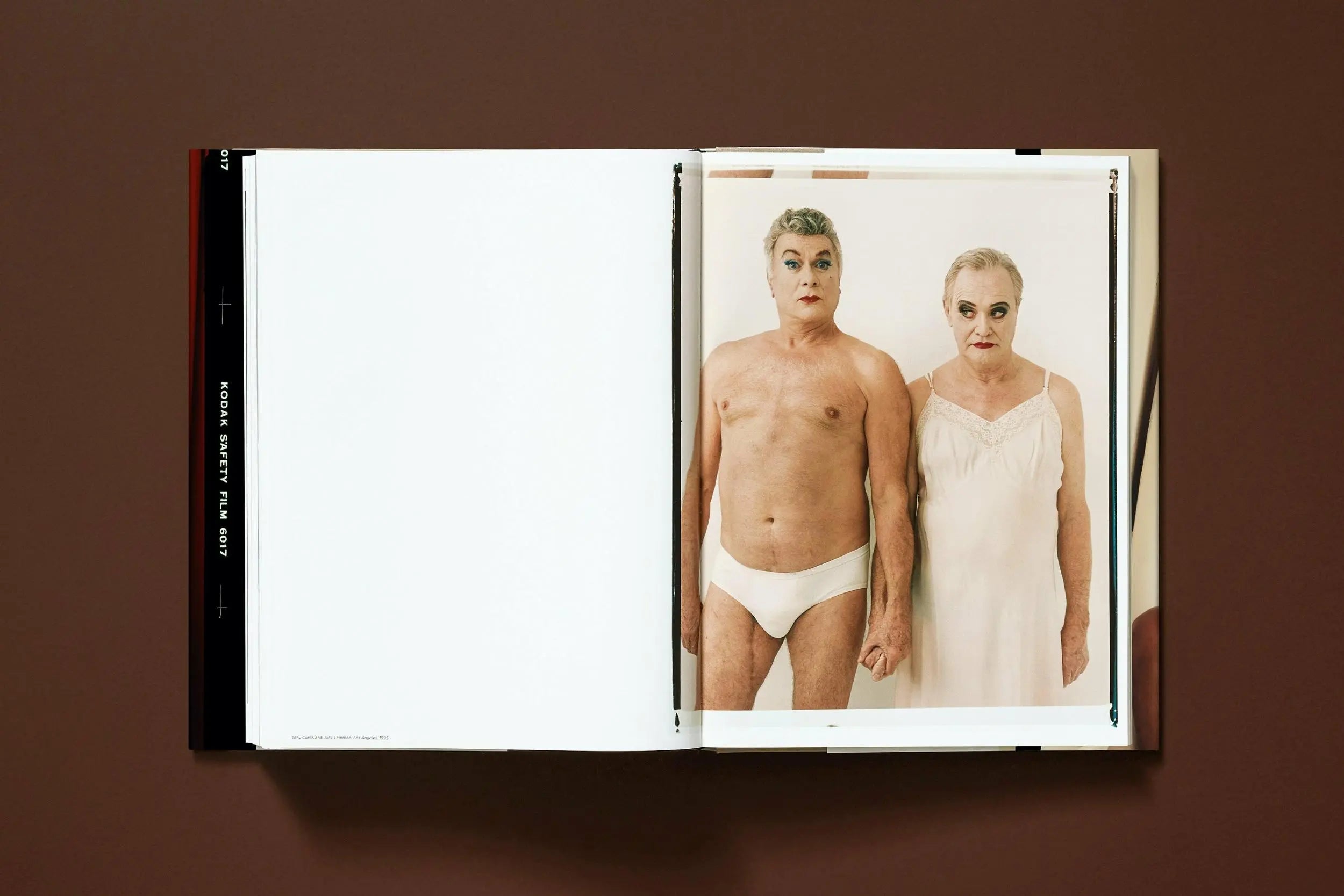 Un libro abierto muestra una foto de dos personas maquilladas, una en ropa interior y otra en camisón.