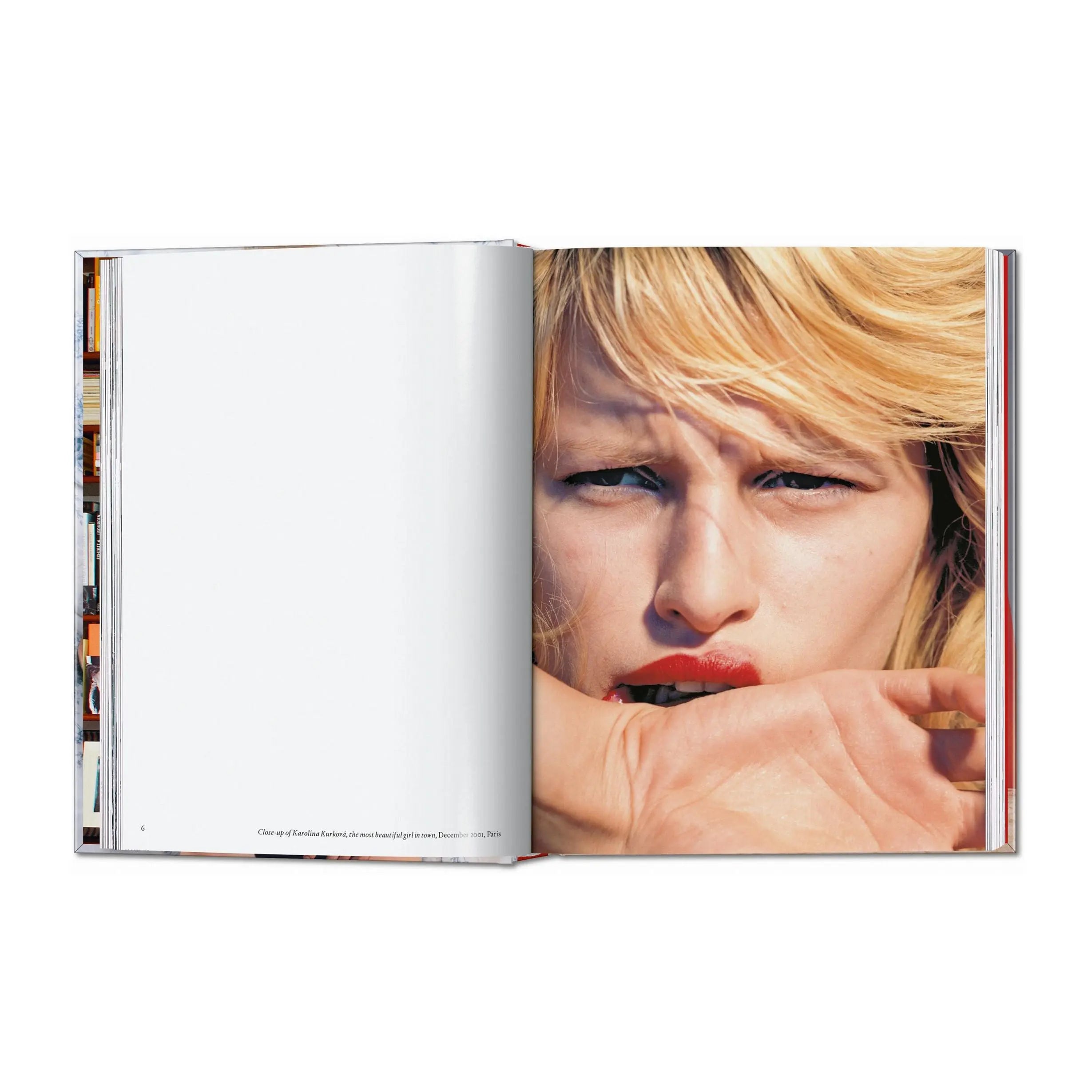 Un libro abierto muestra una foto de una mujer rubia con labios rojos mordiéndose la mano.