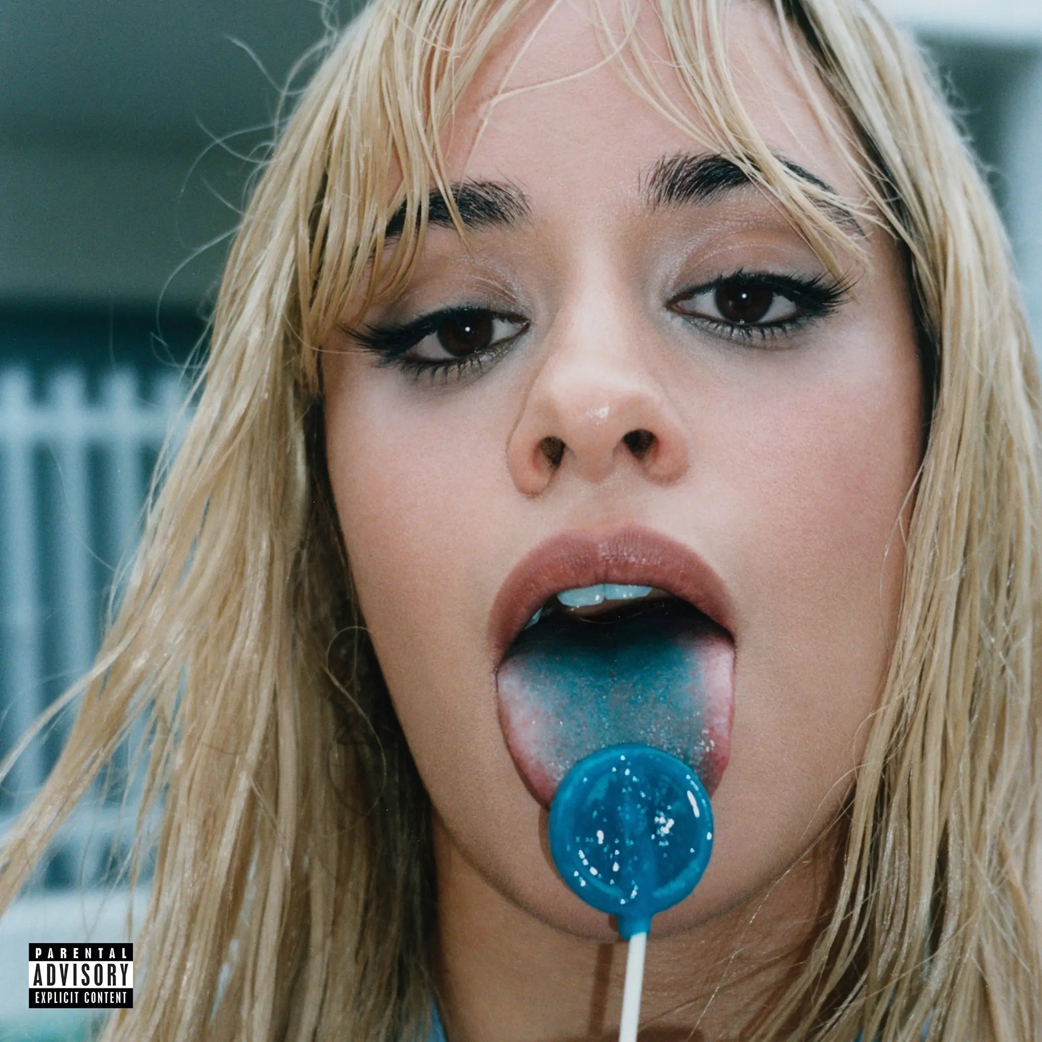 Camila Cabello con cabello rubio y un chupete azul en la boca.