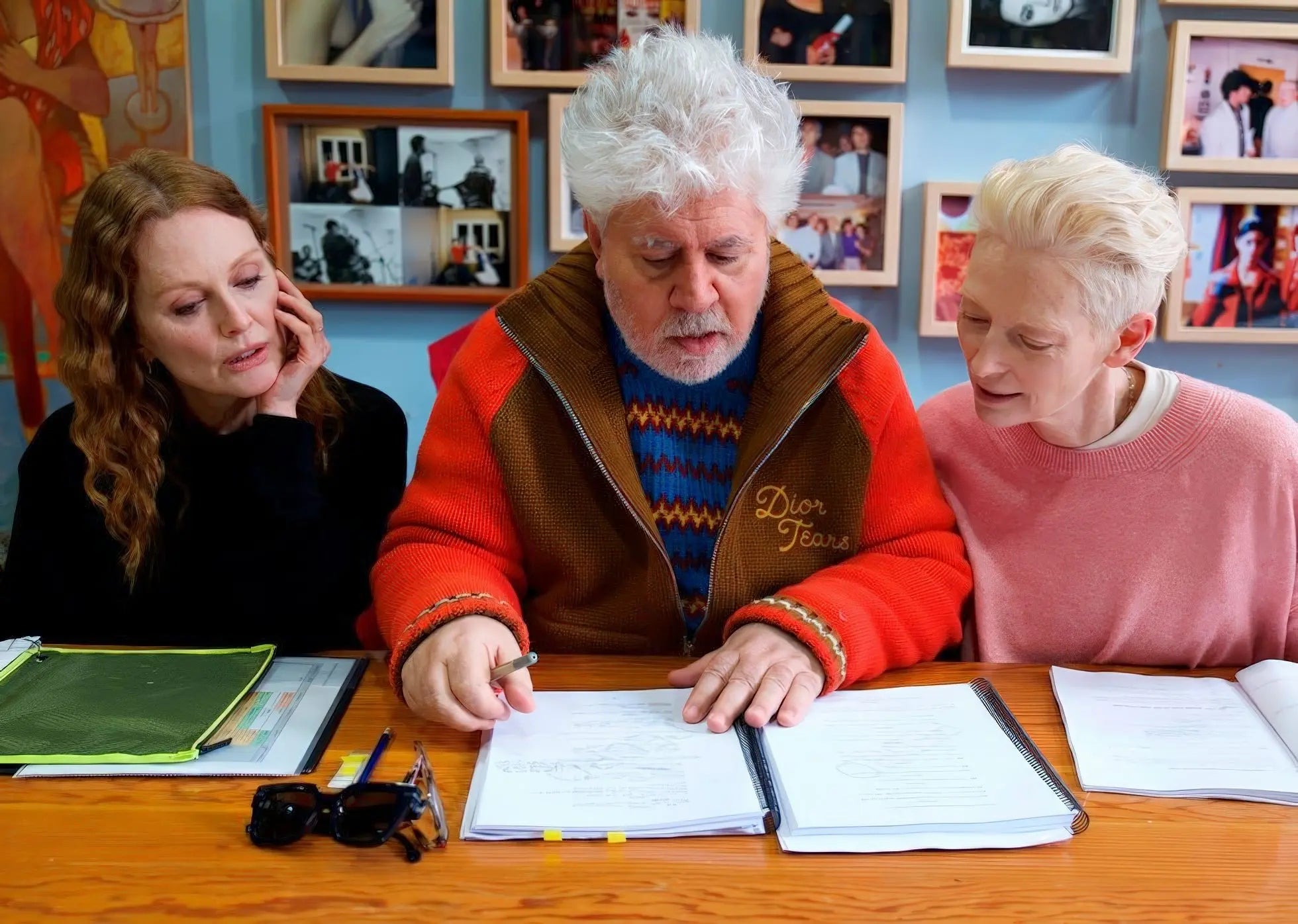 Pedro Almodóvar, Julianne Moore y Tilda Swinton revisan un guion en una mesa.