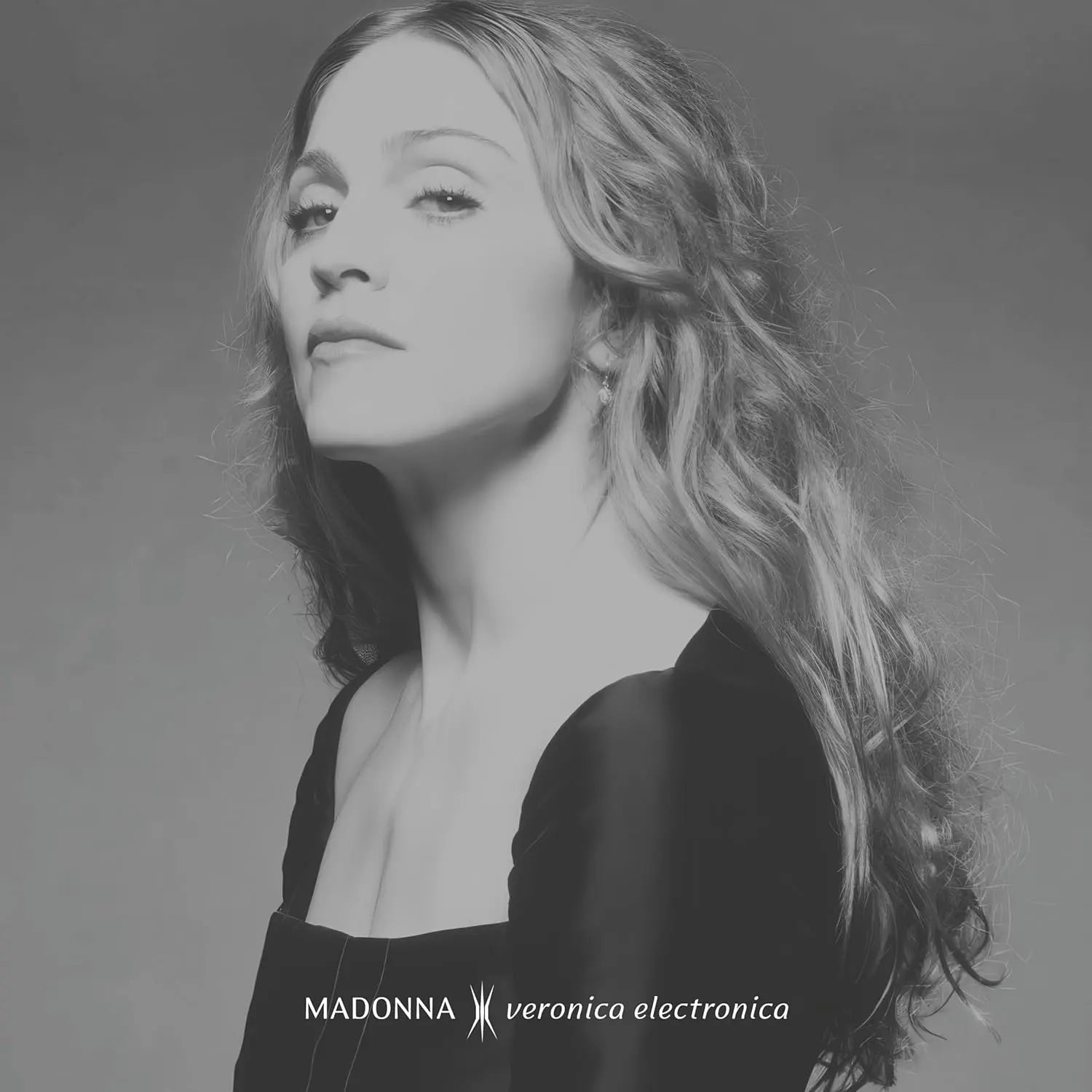 A black and white image of Madonna with long, wavy hair, looking to the left.