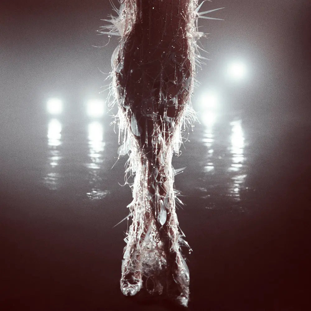 Translucent vinyl with a textured, spiky surface, reflecting bright lights in a dark, misty setting.