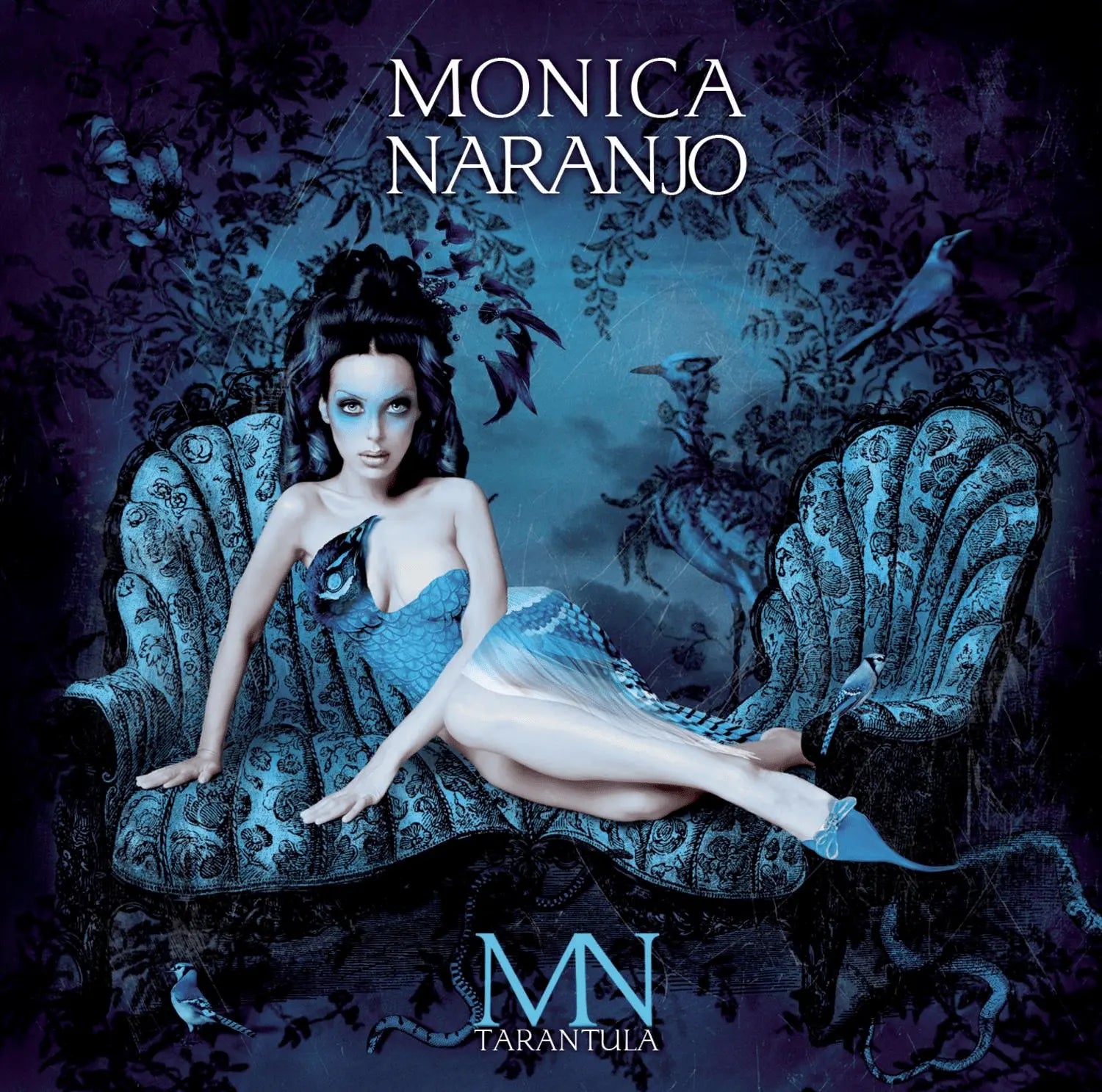 Mónica Naranjo – Tarántula album cover featuring a woman in blue on a patterned couch.