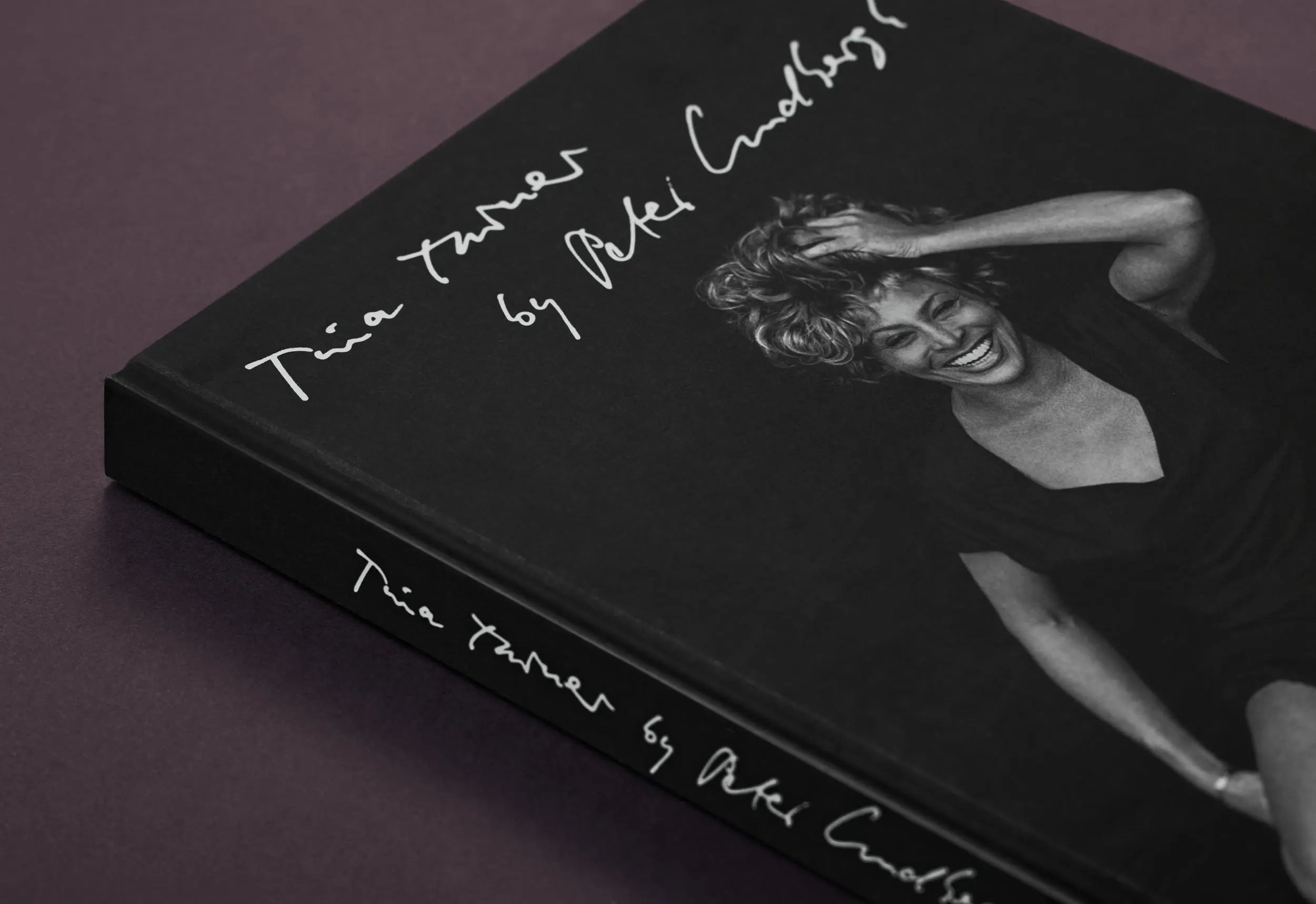A black book titled "Tina Turner by Peter Lindbergh" features a smiling photo of Tina Turner.